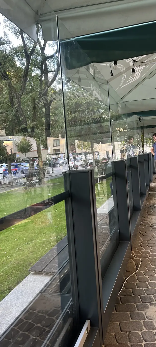 Ogródek restauracji w Krakowie, szklane osłony na grafitowych słupkach