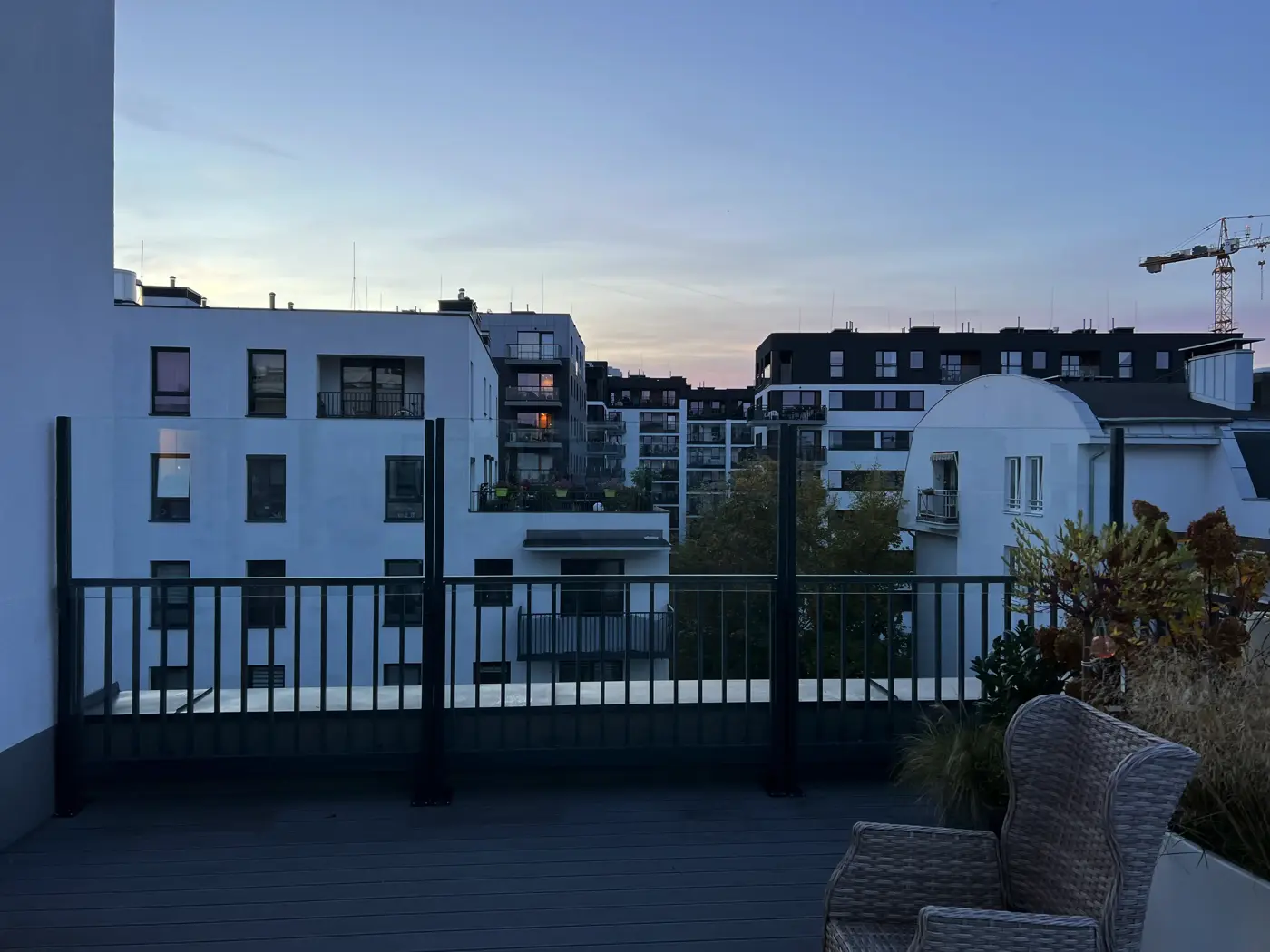 Taras apartamentu w Poznaniu o zmierzchu, szklane osłony na grafitowych słupkach