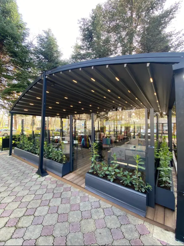 Taras restauracji z pergolą i osłonami na donicach